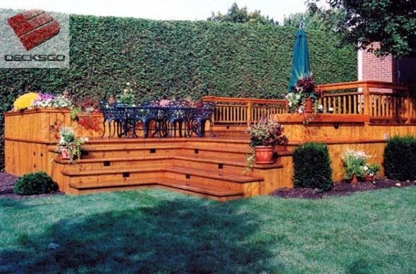 a wooden deck in the middle of a yard