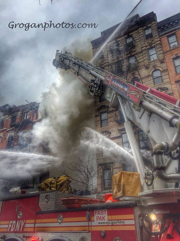 a fire truck with water pouring out of it's hoses in front of a building