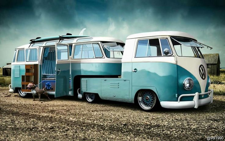 an old blue and white bus parked in the dirt with two surfboards on it's roof