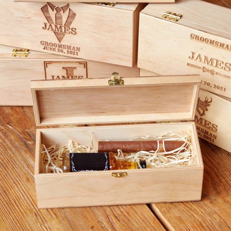 four wooden boxes with different types of cigars in them sitting on a wood table