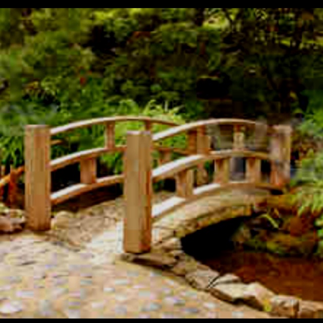 a small wooden bridge in the middle of a garden