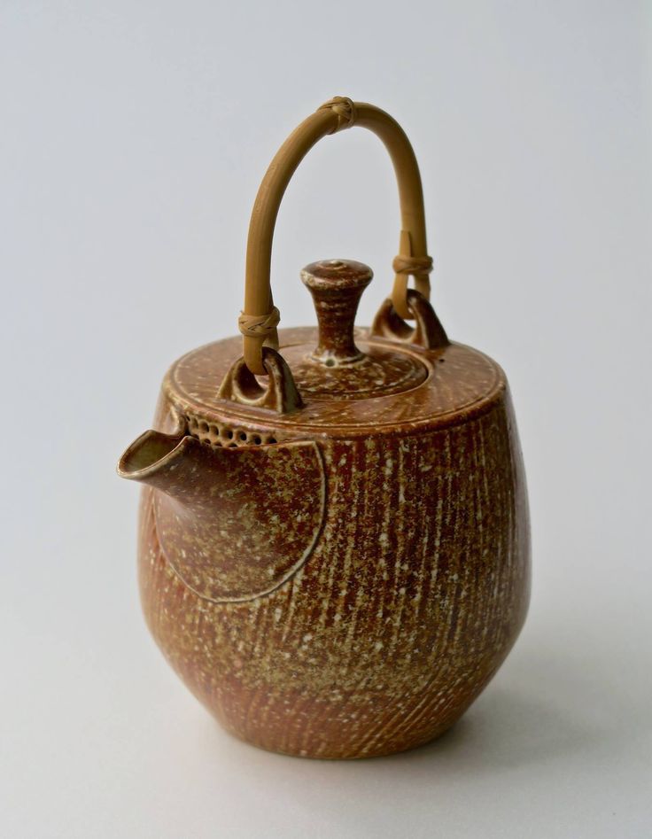 a brown tea pot sitting on top of a white table