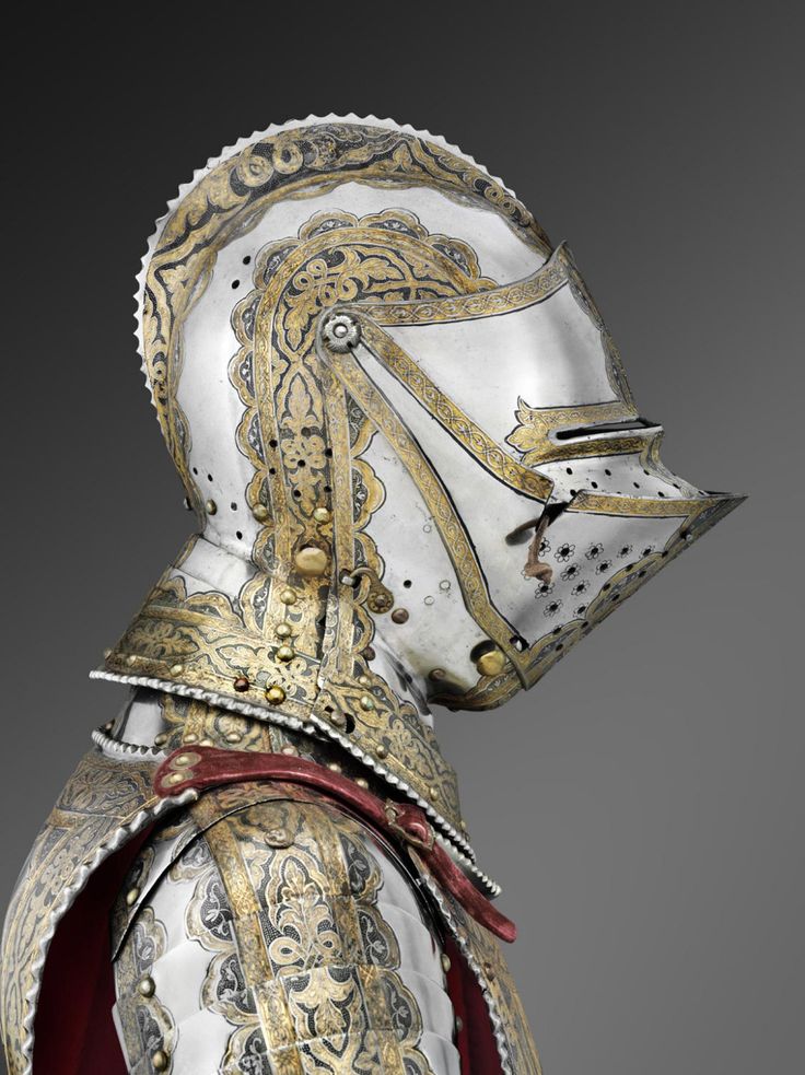 a close up of a knight's armor with gold and silver designs on it