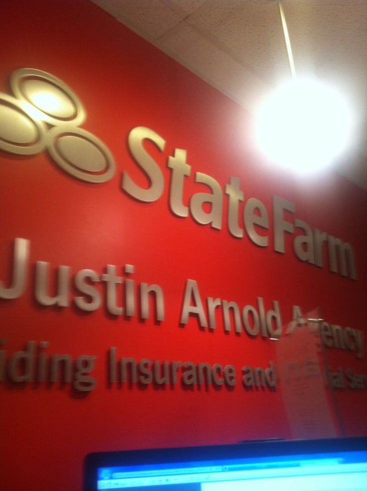 the state farm sign is lit up in front of a computer monitor and laptop screen