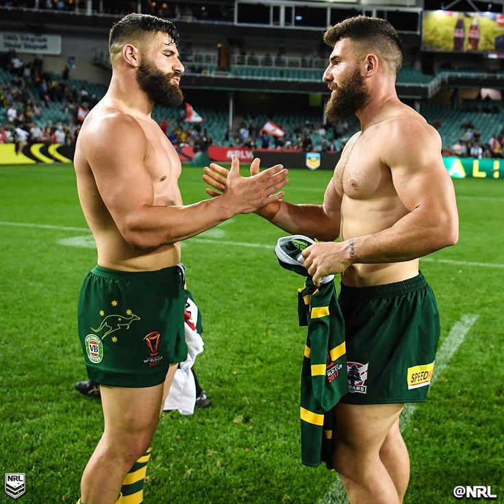 two men in green and yellow shorts standing next to each other on a soccer field