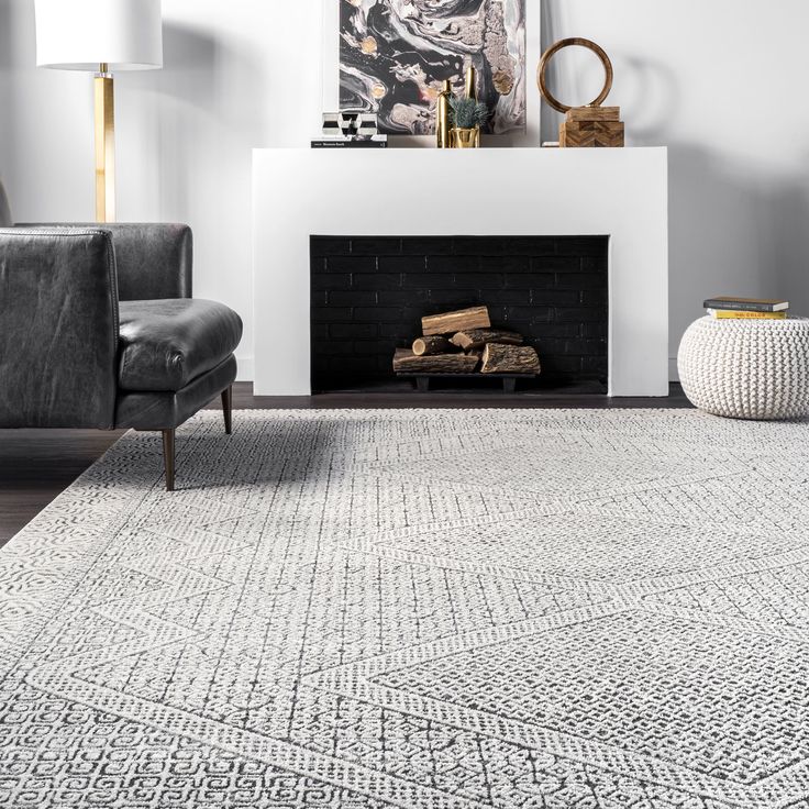 a living room with a fireplace, chair and rug