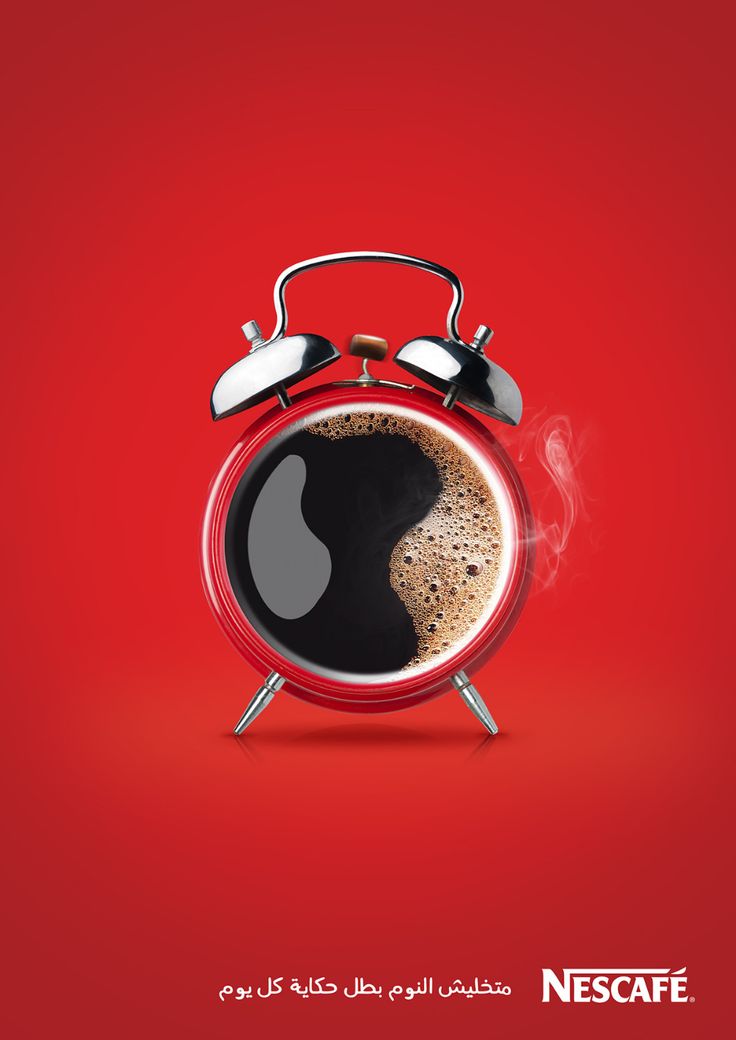 an alarm clock with a cup of coffee in the middle on a red table top