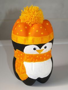 a penguin wearing a hat and scarf with an orange pom - pom on its head