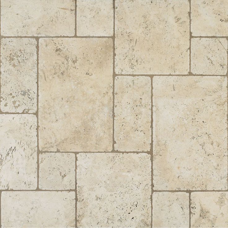 a close up view of a stone floor with white and tan colors on the tiles