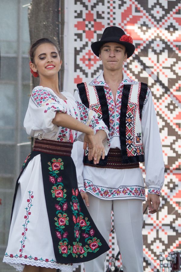 two people dressed in folk clothing standing next to each other with their hands on the hips