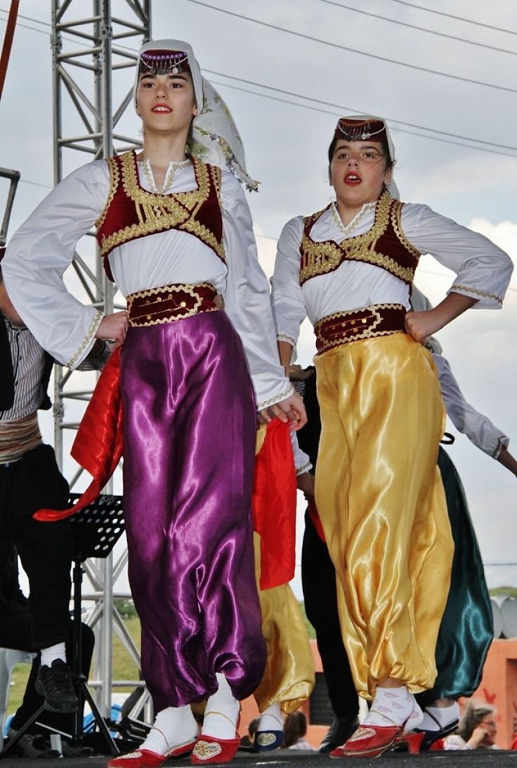 two women in colorful clothing standing on stage