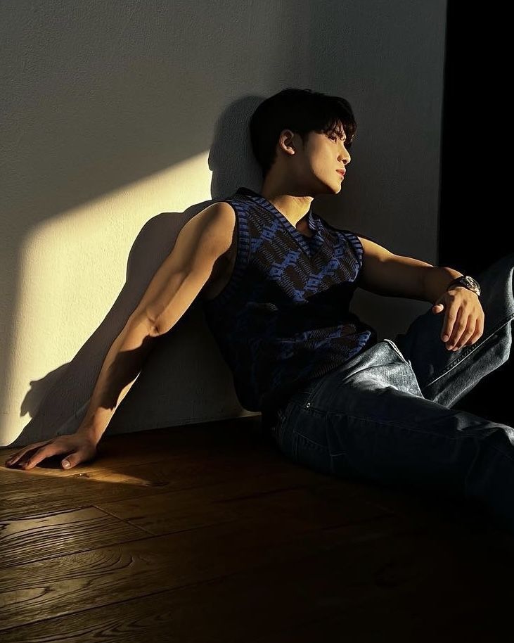 a young man sitting on the floor with his legs crossed