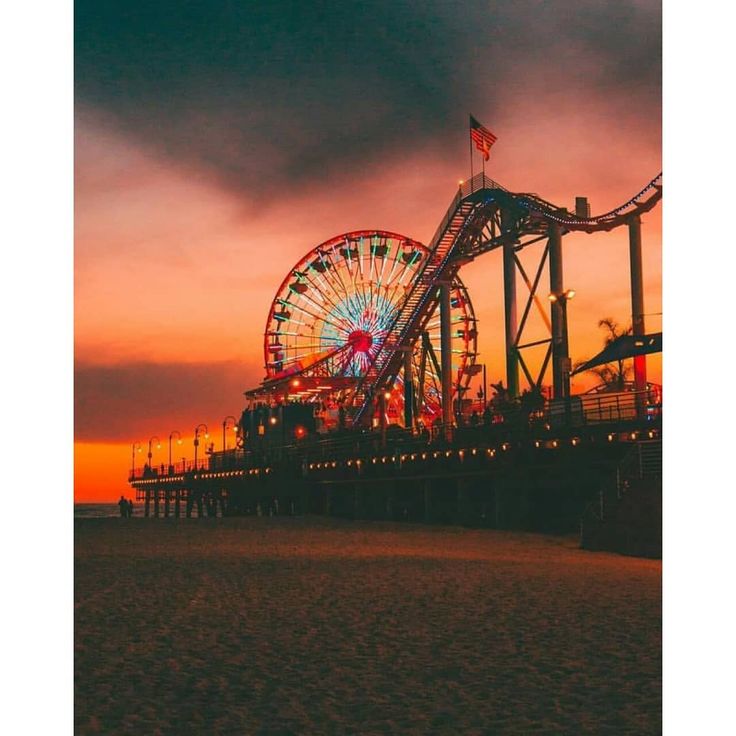 a ferris wheel sitting on top of a sandy beach