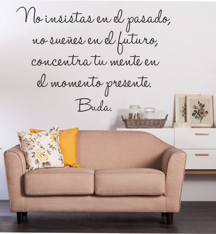 a living room with a couch and wall decal on the wall, in spanish