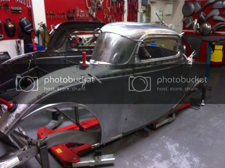 an old car being worked on in a garage