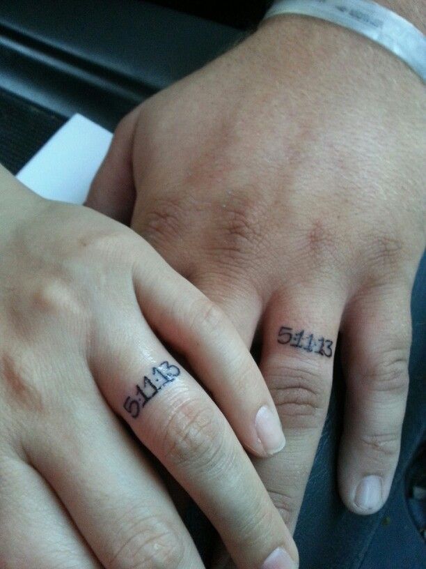 two people holding hands with tattoos on their fingers