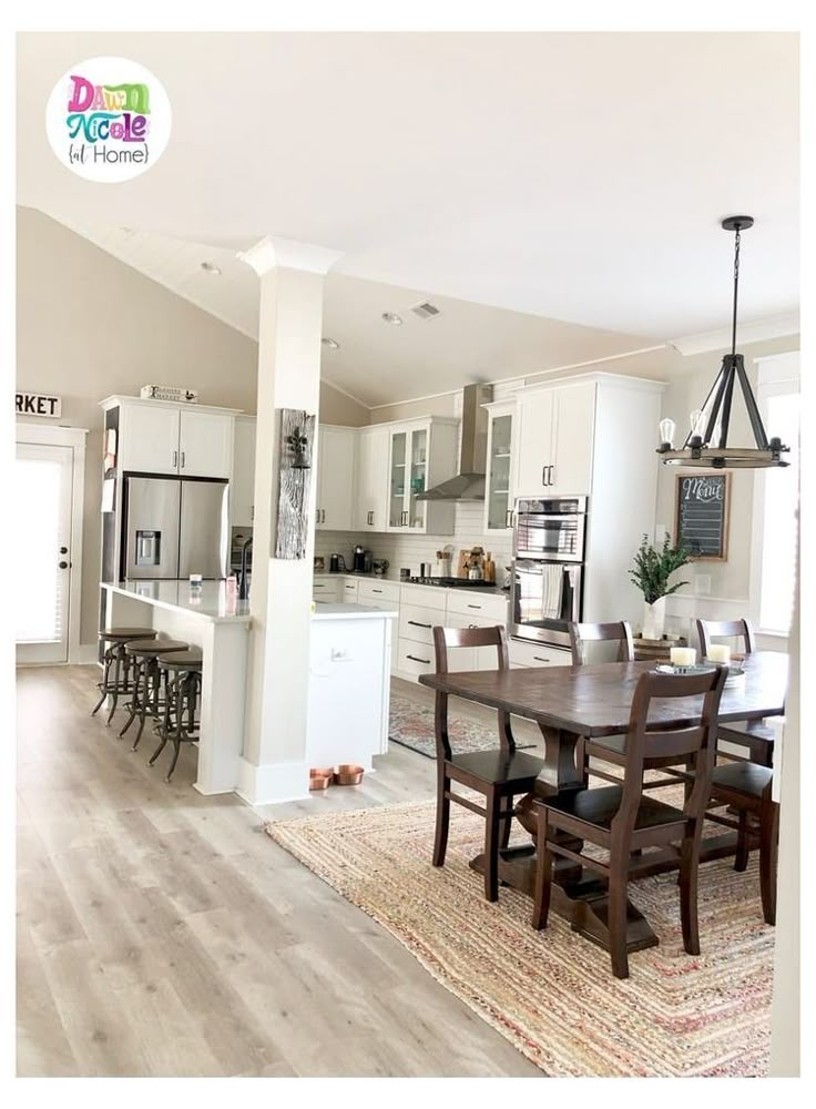 a dining room and kitchen area in a home with hardwood floors, white cabinets, and an open floor plan