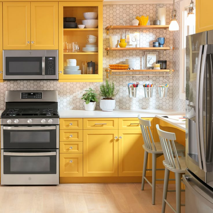 a kitchen with yellow cabinets and stainless steel appliances