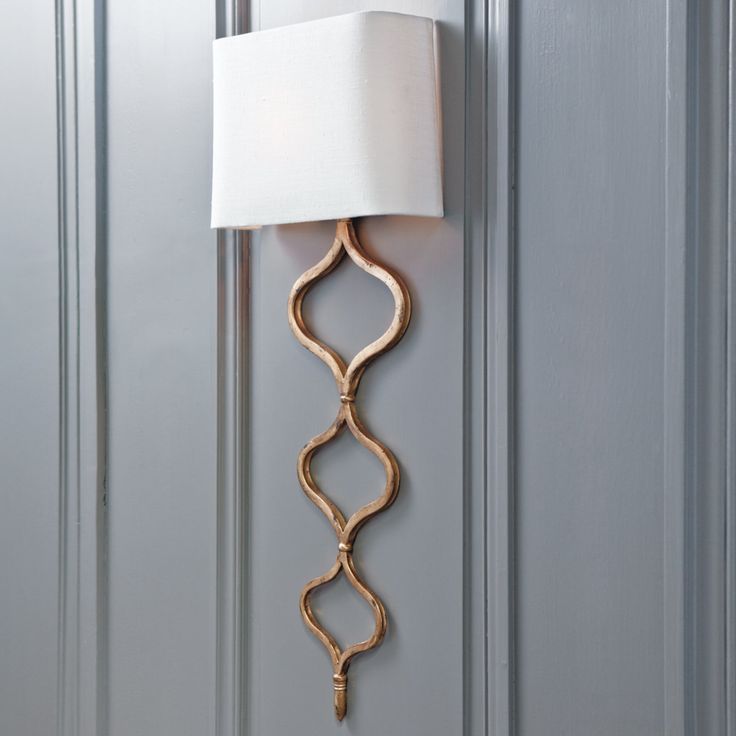 a lamp that is on the side of a door with a white shade over it