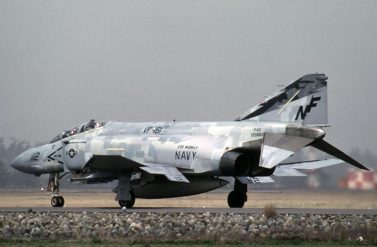 a fighter jet sitting on top of an airport runway