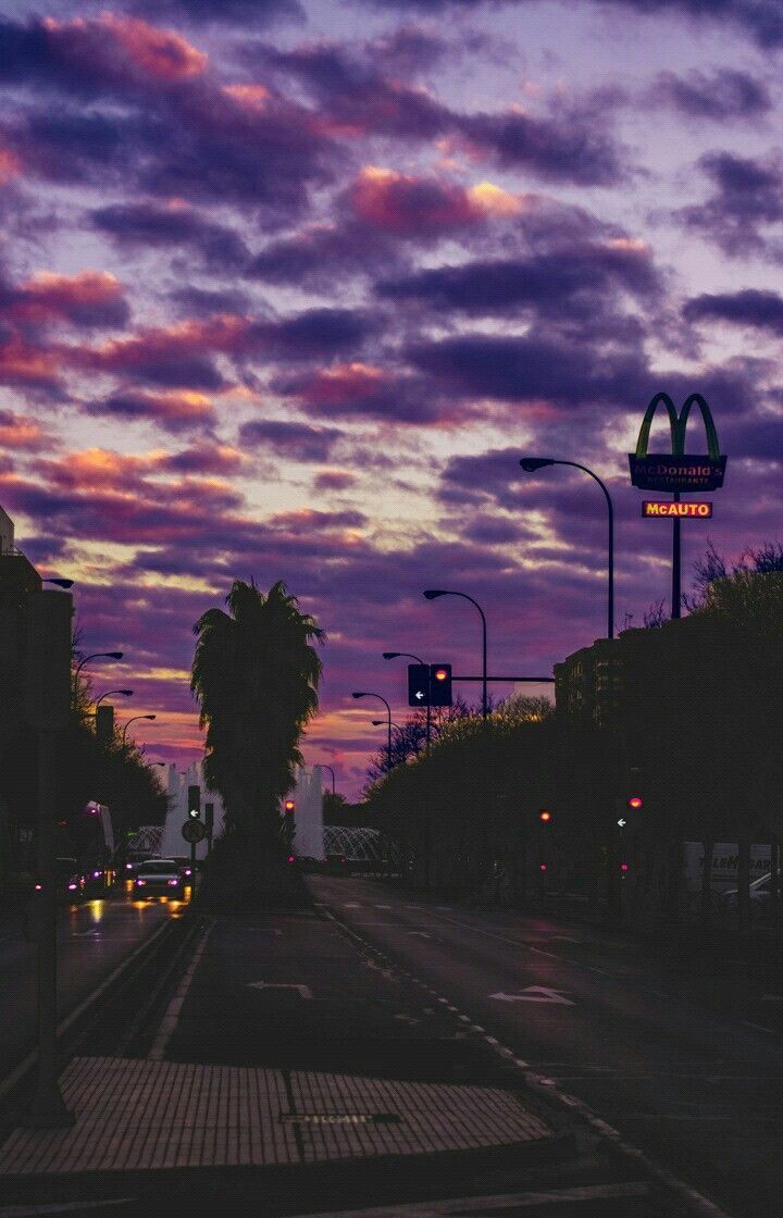 the sky is purple and pink at night with clouds in the backgrounnd