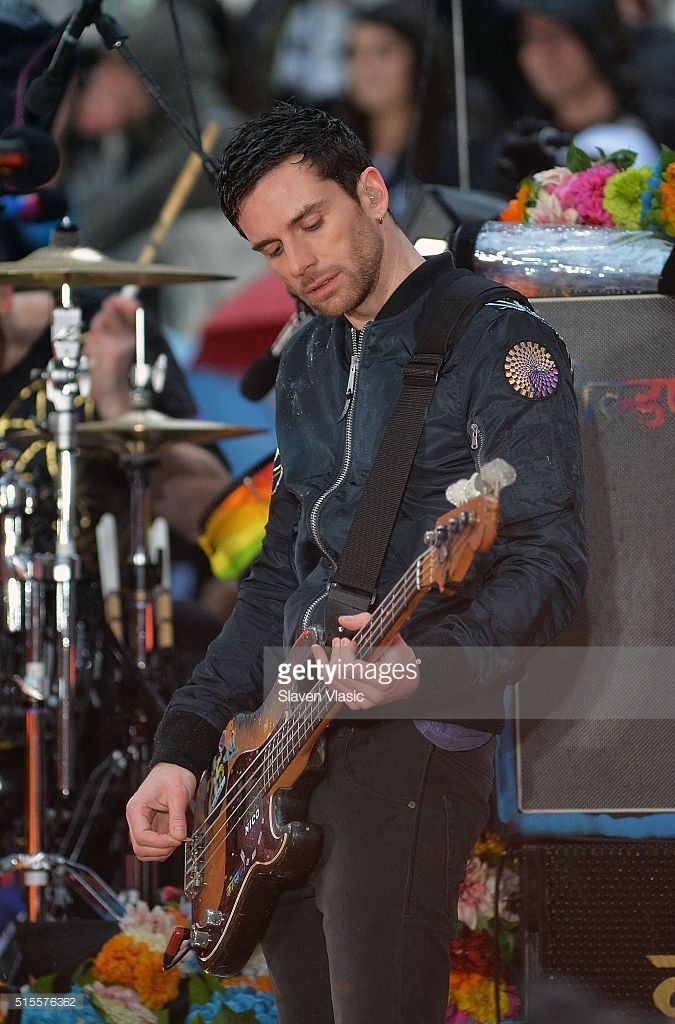 a man playing a bass guitar on stage