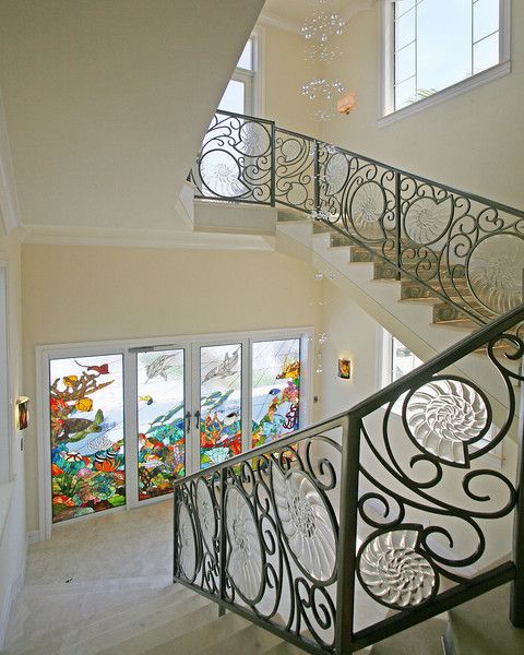 a staircase with glass windows and wrought iron railing