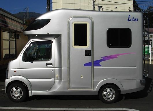 a silver truck is parked on the side of the road in front of a building