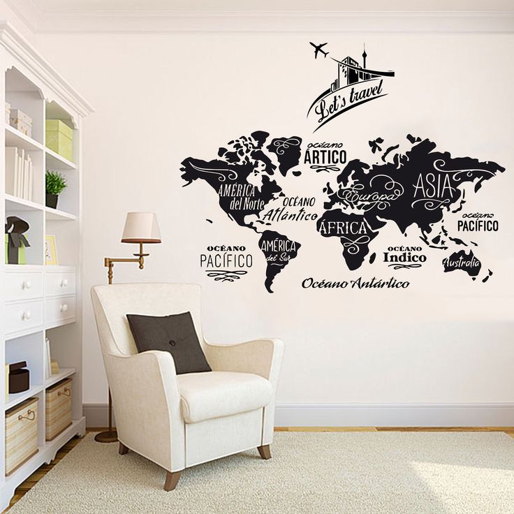 a living room with a white chair and a black world map wall sticker on the wall