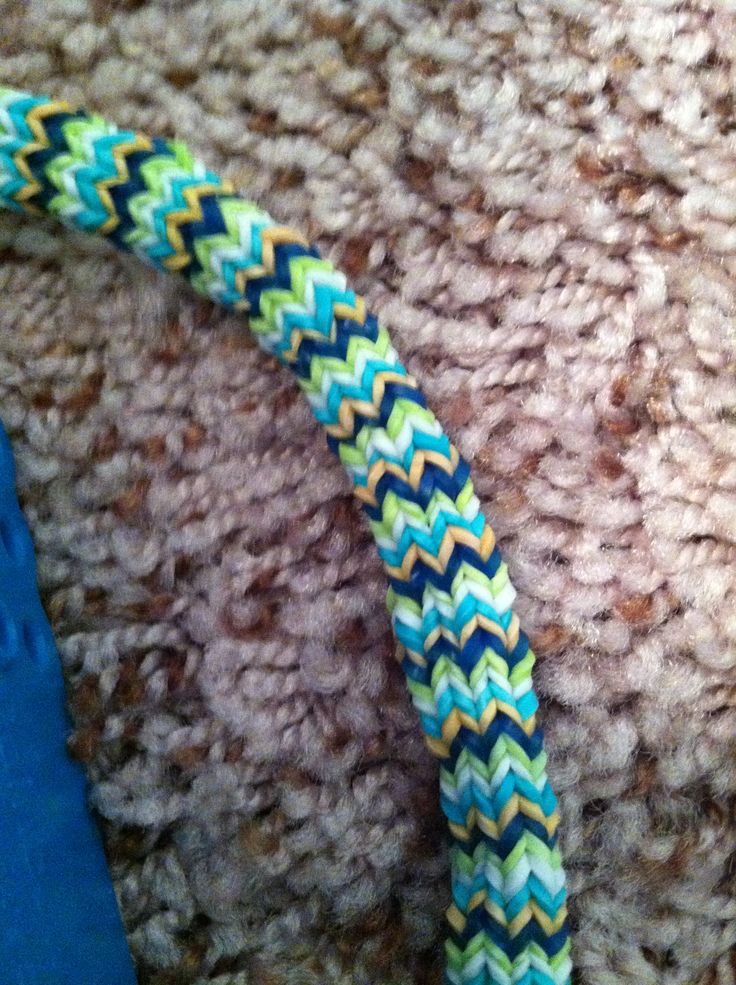 a close up view of a blue and yellow braided object on the carpet with scissors