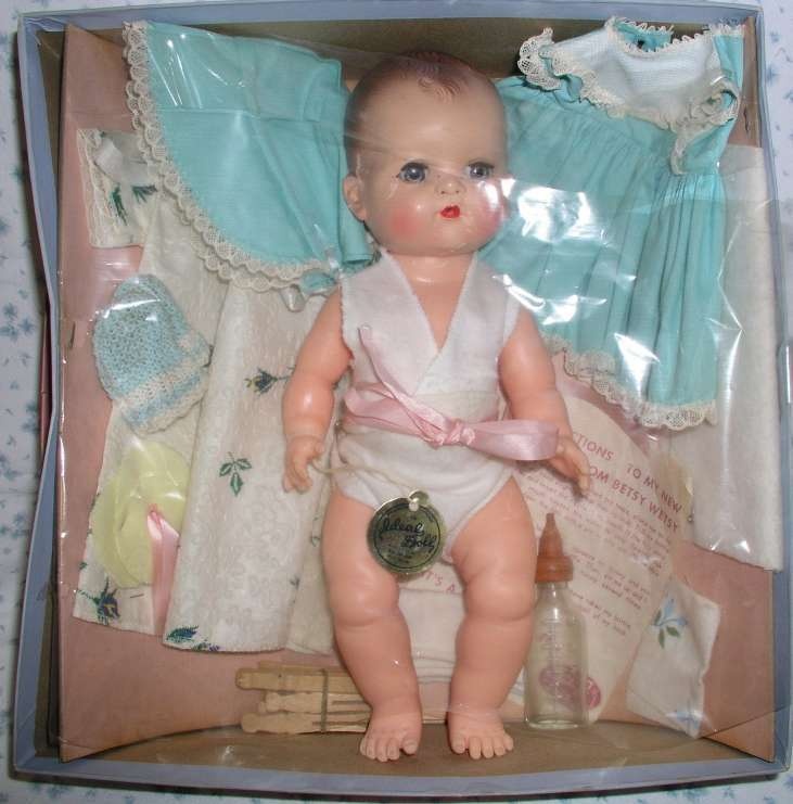 a baby doll in a box with clothes