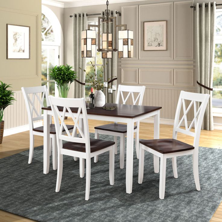 a dining room table and chairs with a rug on the floor