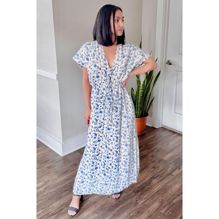 Radiate summer vibes with our 'Gathered Maxi Dress in Blue Florals.' Crafted from 100% Bemberg™ Crepe, this dress in white and blue exudes summery elegance. Whether worn solo or as a chic beach cover-up, its relaxed fit and drawstring waist ensure comfort and style. Featuring side slits and pockets on both sides, this maxi dress is a must-have addition to your summer wardrobe for beach days or casual outings. Relaxed Fit V-neck Midi Dress For Beach, Casual Blue V-neck Beach Dress, Relaxed Fit V-neck Maxi Dress For Summer, Spring Vacation Short Sleeve Maxi Dress, Light Blue V-neck Maxi Dress For Beach, Spring Short Sleeve Maxi Beach Dress, Spring Beachwear Maxi Dress With Short Sleeves, Light Blue V-neck Midi Dress For Beach, Casual Printed Beach Dress For Brunch