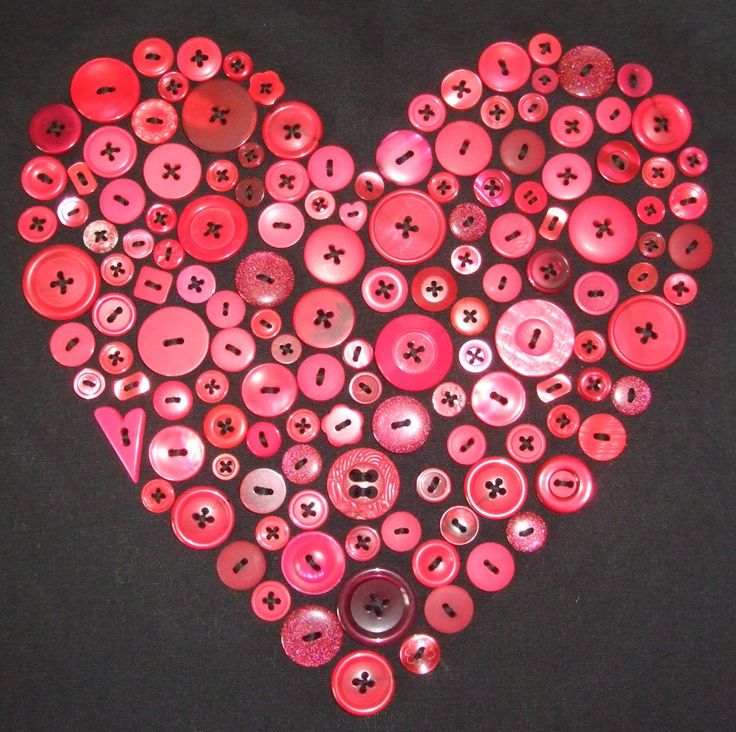 a heart made out of buttons on a black background