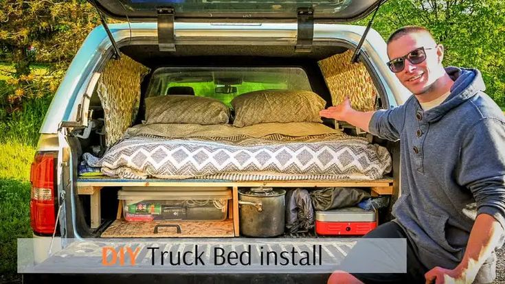 a man is sitting in the back of a truck with his bed pulled up to it