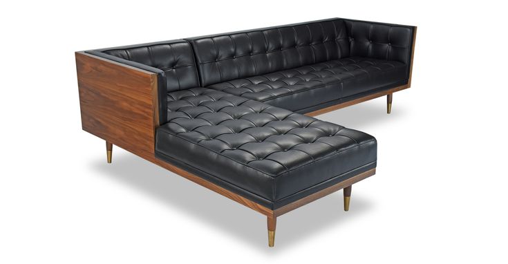 a black leather couch and ottoman with wooden legs