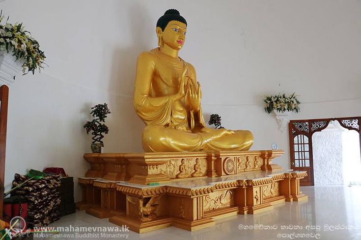 a golden buddha statue sitting in the middle of a room