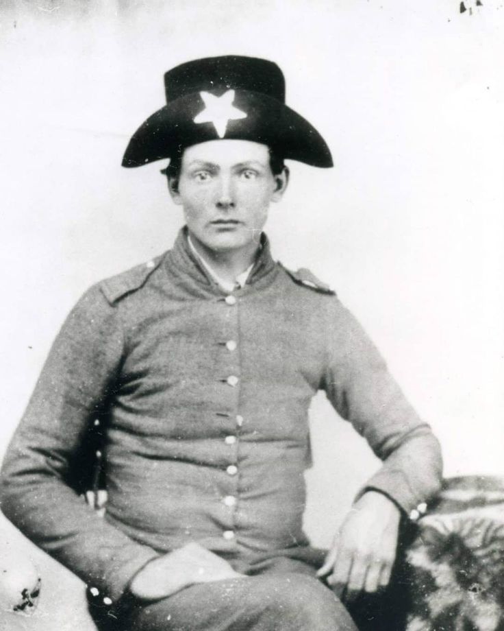 an old black and white photo of a man in uniform