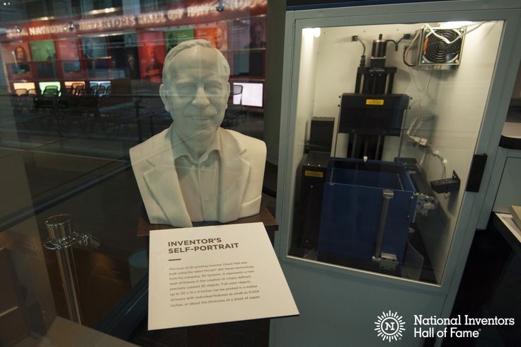 a display case with a statue of a man in a white suit and tie on it