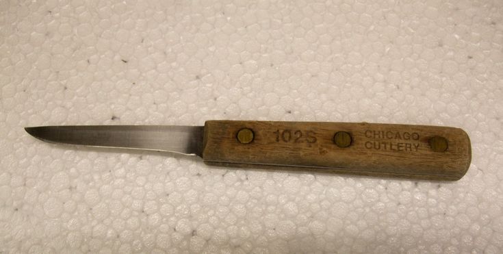 a knife that is sitting on top of a white table cloth with the words chicago cutlery written on it