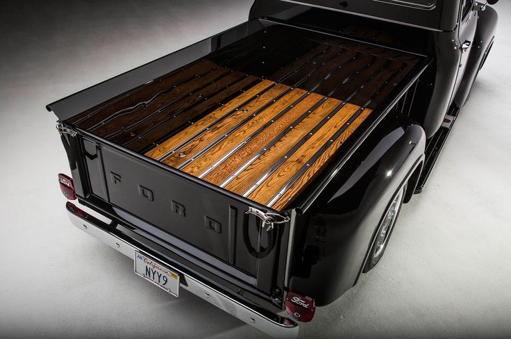 the back end of a pickup truck with wood in it's bed and flatbed