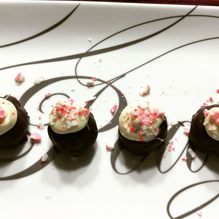 three desserts with white frosting and sprinkles on a plate