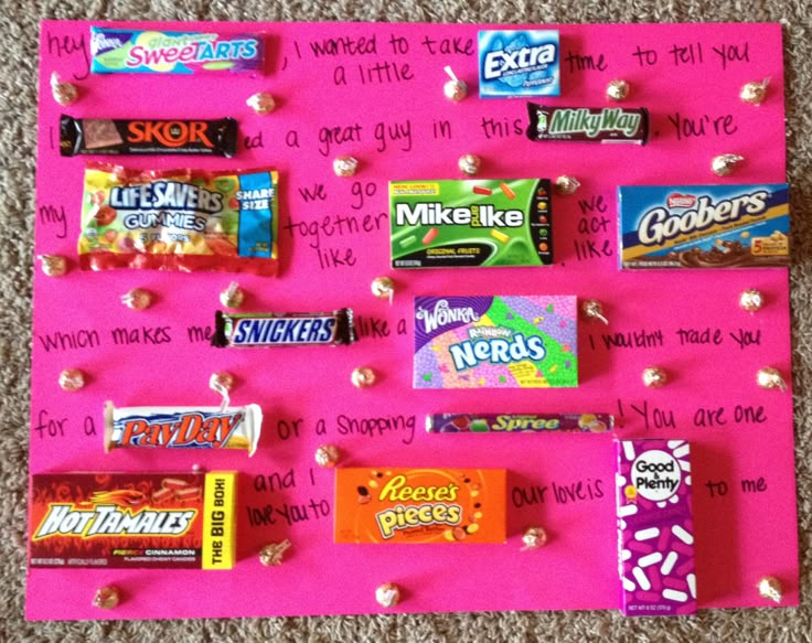 a pink bulletin board with candy bars on it