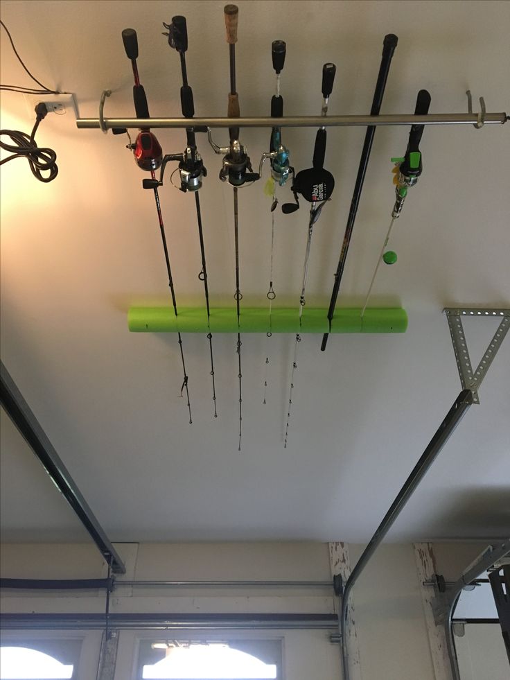 there are many fishing rods hanging from the ceiling