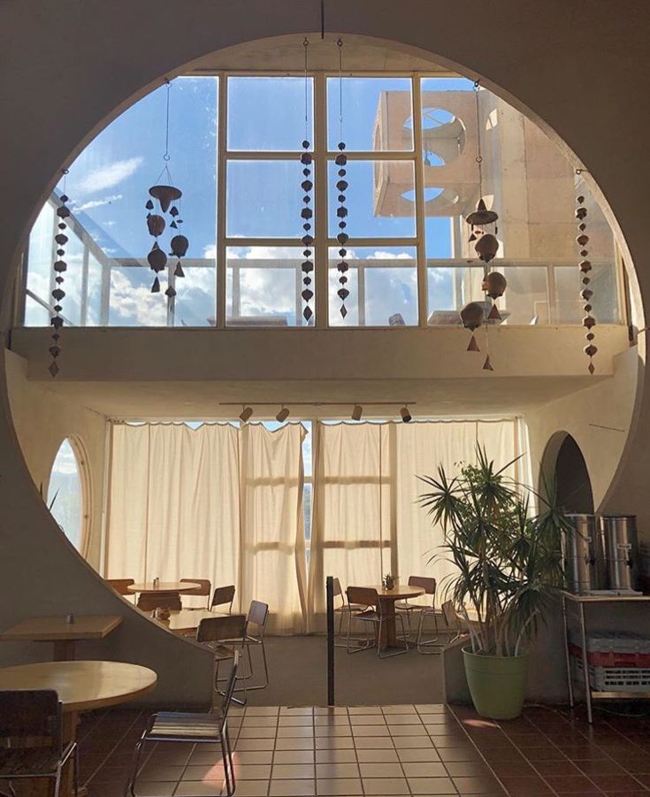 the inside of a building with an arched window and white curtains on the windowsill