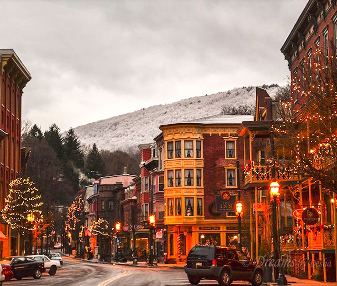 the street is lined with christmas lights and decorated buildings