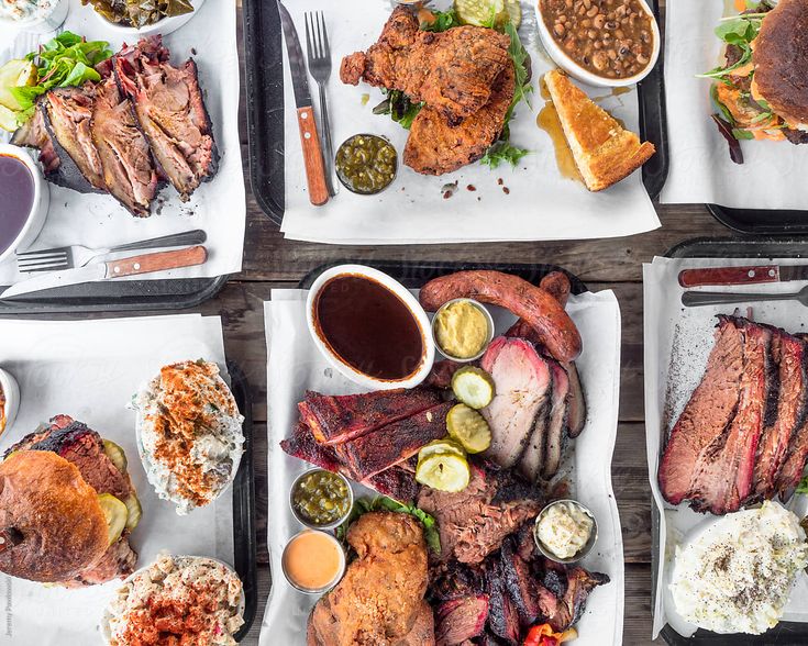 several trays filled with different types of food on top of each other, including meat and sides