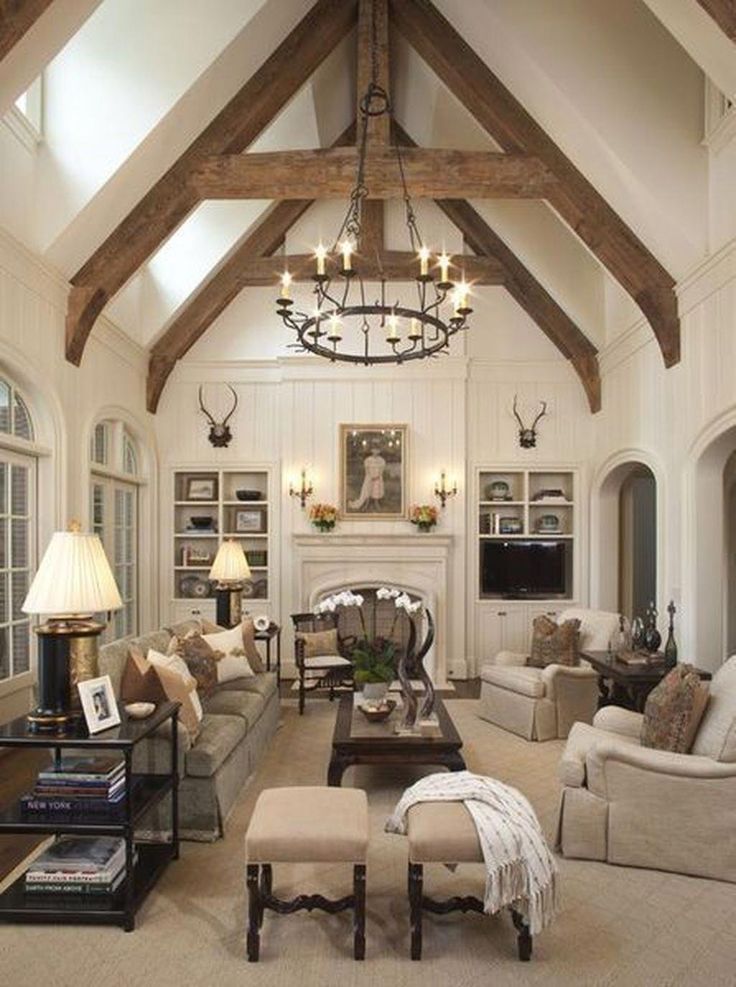 a living room filled with furniture and a chandelier hanging from the ceiling over a fire place