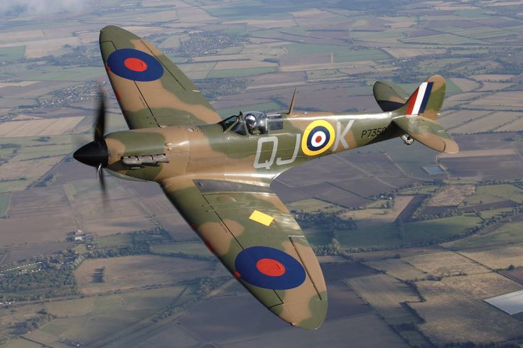 an air plane flying through the sky over land