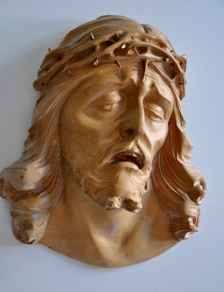 a close up of a statue of jesus wearing a crown of leaves on it's head